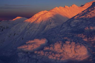 Scenic view of snowcapped mountains against sky during sunset