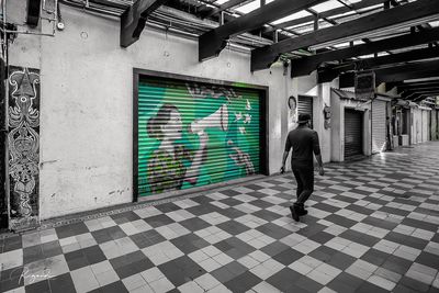 Rear view of man and woman walking on floor in building