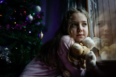 Portrait of girl holding christmas tree