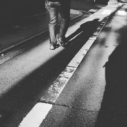 Low section of man walking on street