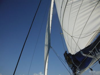 Low angle view of sailboat against clear blue sky