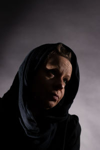 Close-up portrait of man against black background