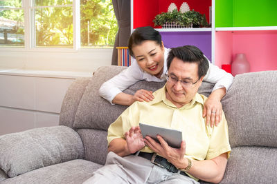 Friends sitting on sofa at home