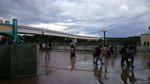 People in city against cloudy sky