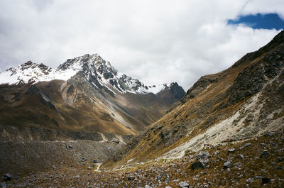 Scenic view of mountains against cloudy sky