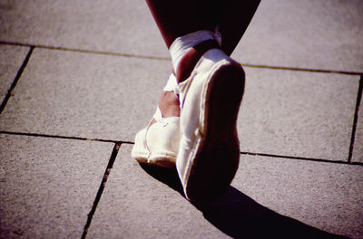 Low section of woman walking on footpath