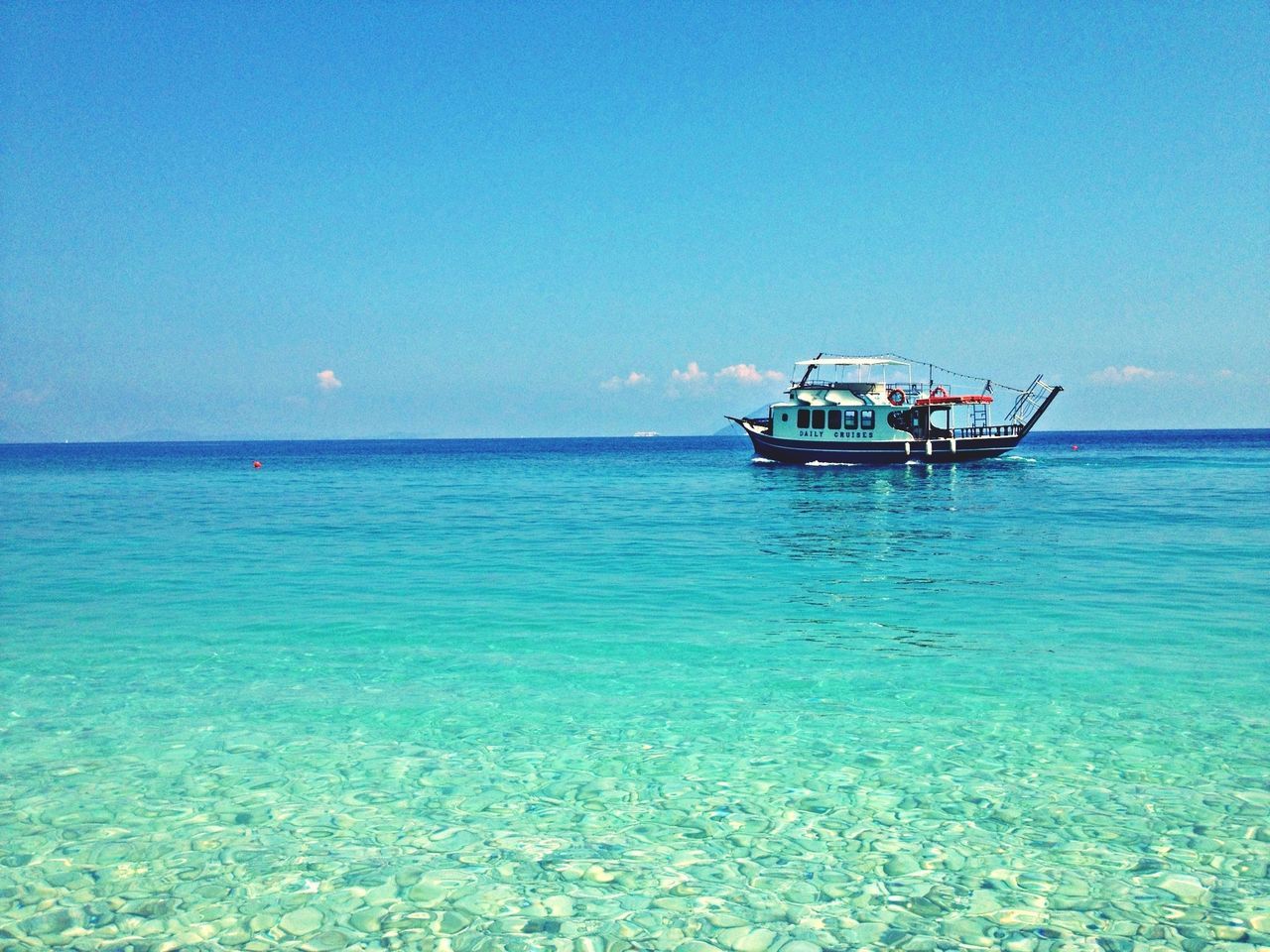 sea, water, nautical vessel, horizon over water, transportation, boat, mode of transport, blue, tranquil scene, waterfront, clear sky, tranquility, scenics, beauty in nature, copy space, nature, sky, rippled, idyllic, sunlight