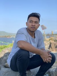 Portrait of young man sitting on land