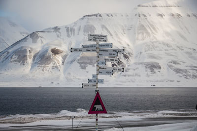 Scenic view of snowcapped mountains by sea against sky