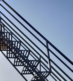 Low angle view of silhouette stairs against clear blue sky