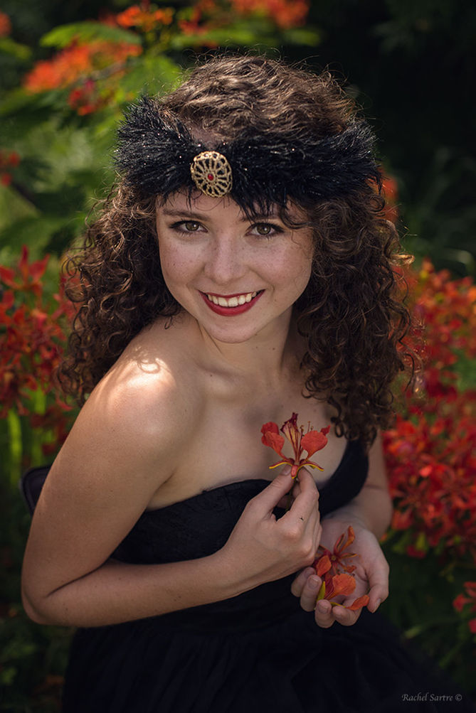 flower, one person, looking at camera, portrait, curly hair, beautiful woman, lifestyles, real people, young adult, young women, fashion, smiling, focus on foreground, beauty, outdoors, leisure activity, nature, day, close-up, freshness, people