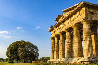 Low angle view of historical building against clear blue sky  , temple of paestum. italy