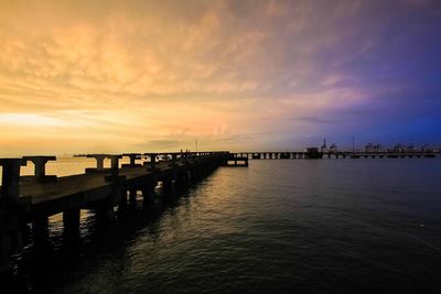 Pier on sea at sunset