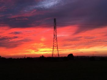 Silhouette of electricity pylon at sunset