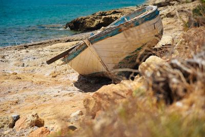 Abandoned boat moored on shore