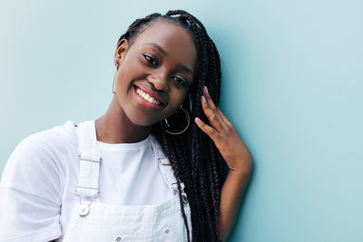 Portrait of young woman against blue background