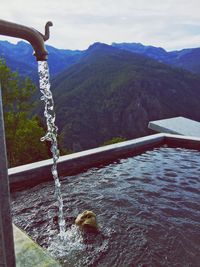 Close-up of water and mountains against sky