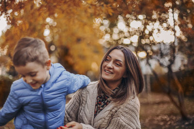 Portrait of happy friends standing against trees