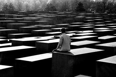 Rear view of man sitting on berlin holocaust memorial site