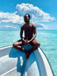 Rear view of man swimming in sea against sky