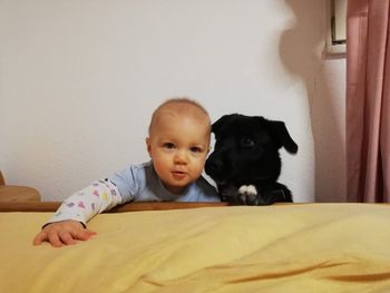 Portrait of cute baby girl lying on bed at home