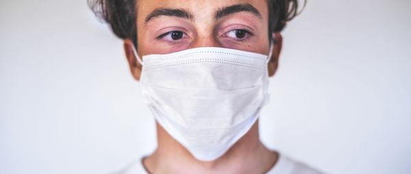 Portrait of man wearing mask against white background