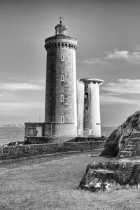 Lighthouse by sea against sky