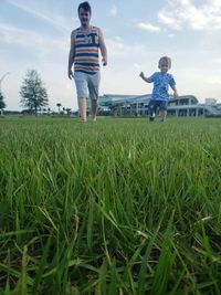 Full length of children on field against sky