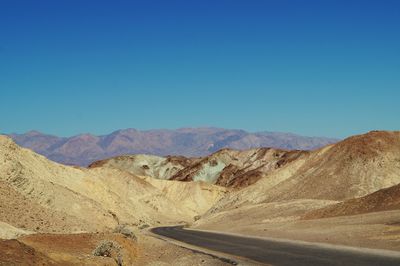 Scenic view of arid landscape against clear blue sky