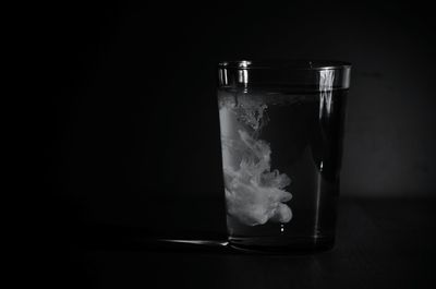 Paint with water in drinking glass against wall