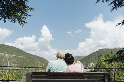 Back view of senior couple sitting on a bench looking at view, jaca, spain