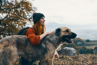 Woman with dog against sky