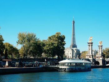 Boat in river with eiffel tower in background against sky
