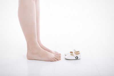 Low section of woman with baby shoes