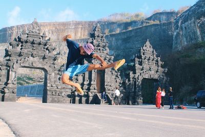 People jumping against mountains in city