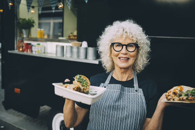 Portrait of smiling woman holding food