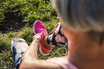 Sportive senior woman tying her shoes