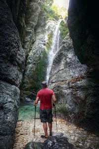 Full length rear view of man standing on rock