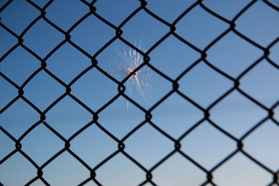 Full frame shot of chainlink fence against blue sky