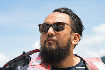Close-up of man wearing sunglasses against sky