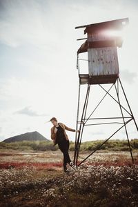 Full length of woman standing on field against sky