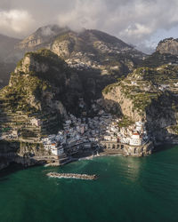 Scenic view of sea and mountains against sky