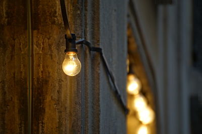 Low angle view of illuminated light bulbs at night