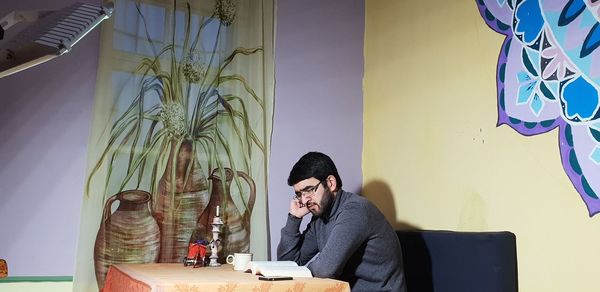 Man working on table against wall