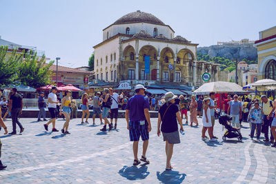 People walking on street against buildings in city