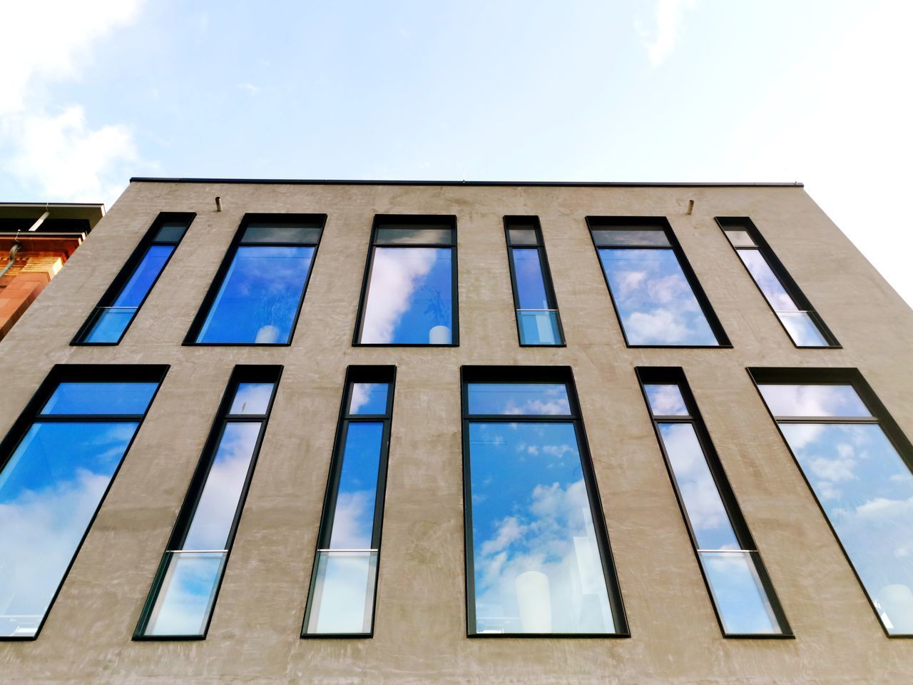 LOW ANGLE VIEW OF BUILDING AGAINST CLOUDY SKY