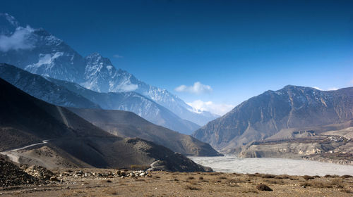 Scenic view of mountains against blue sky