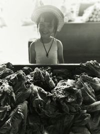Smiling girl standing in front of vegetable stall in market