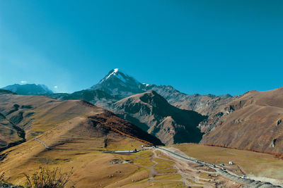 Scenic view of snowcapped mountains against clear blue sky