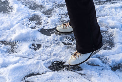 Low section of person standing on frozen lake